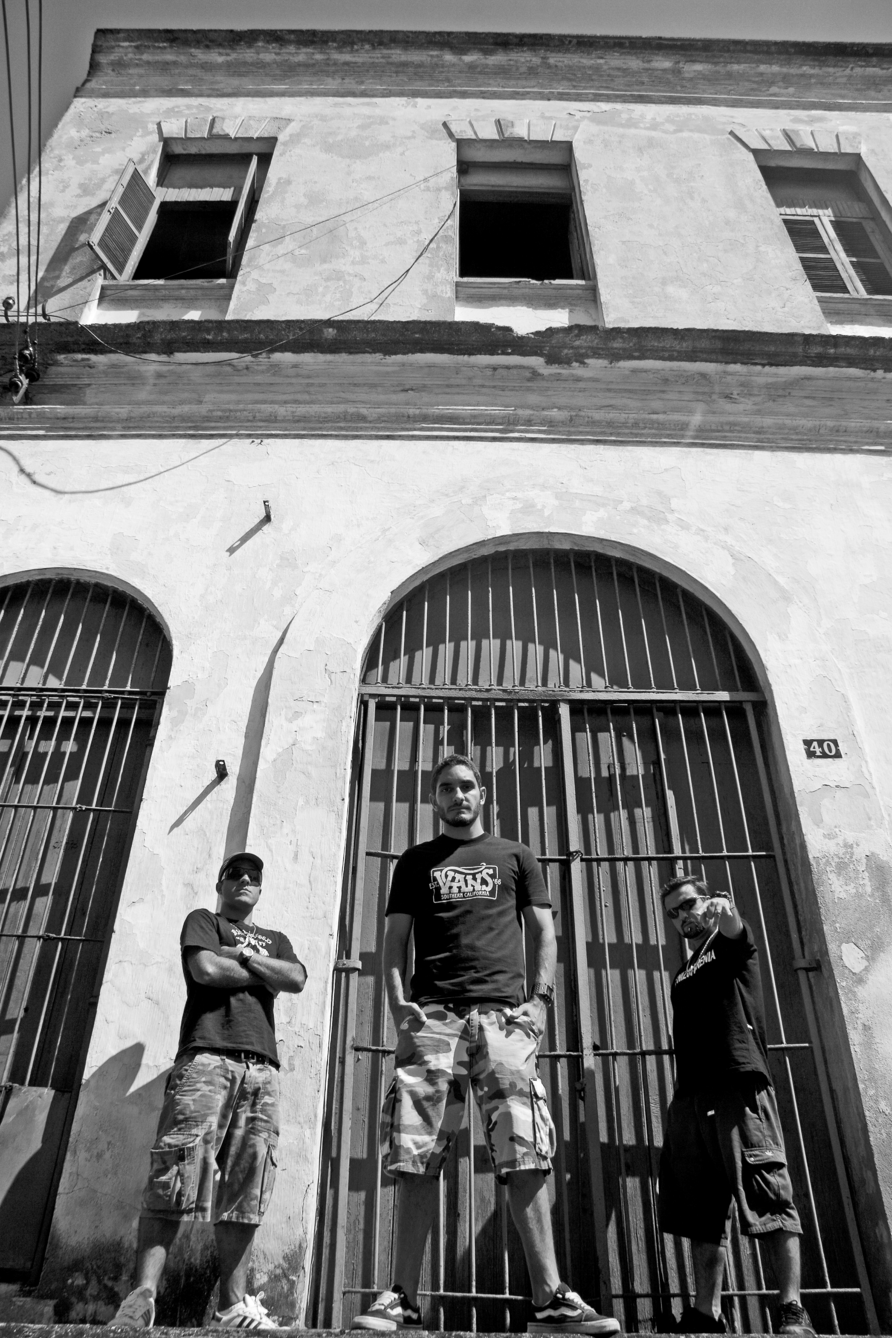 Integrantes do Schizophrenia posando em frente a portão colonial com grades